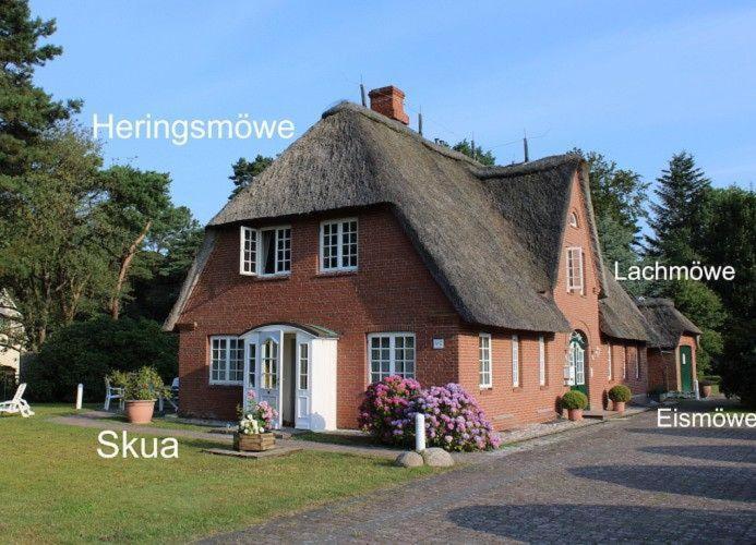 a large red brick house with a thatched roof at Eismoewe in Nebel