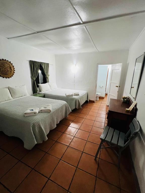 a bedroom with two beds and a table and a bench at #6- Rancho Meling in Camalú