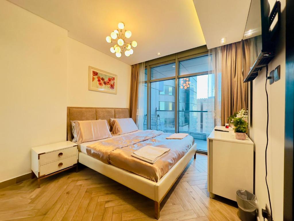a bedroom with a bed and a large window at Sea View Apartment in Era View in Manama