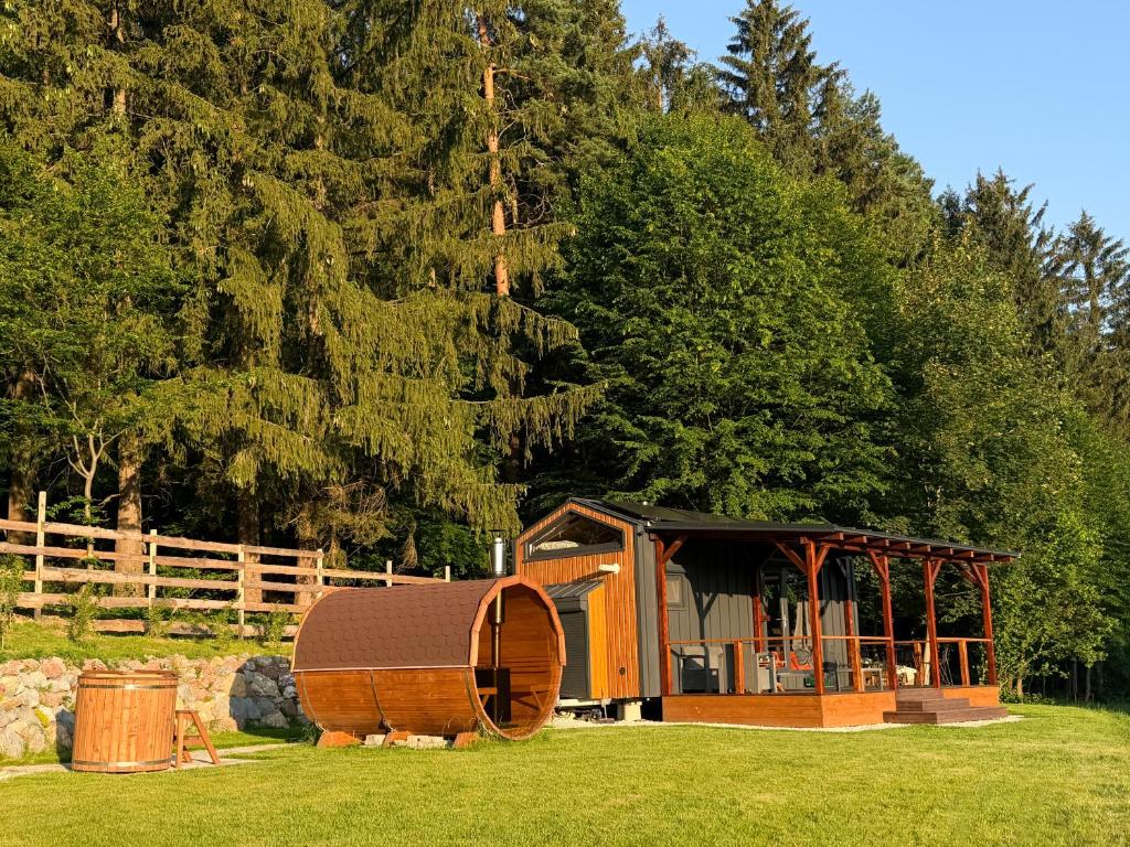 a small cabin in a field with trees at Čiles in Kostolec