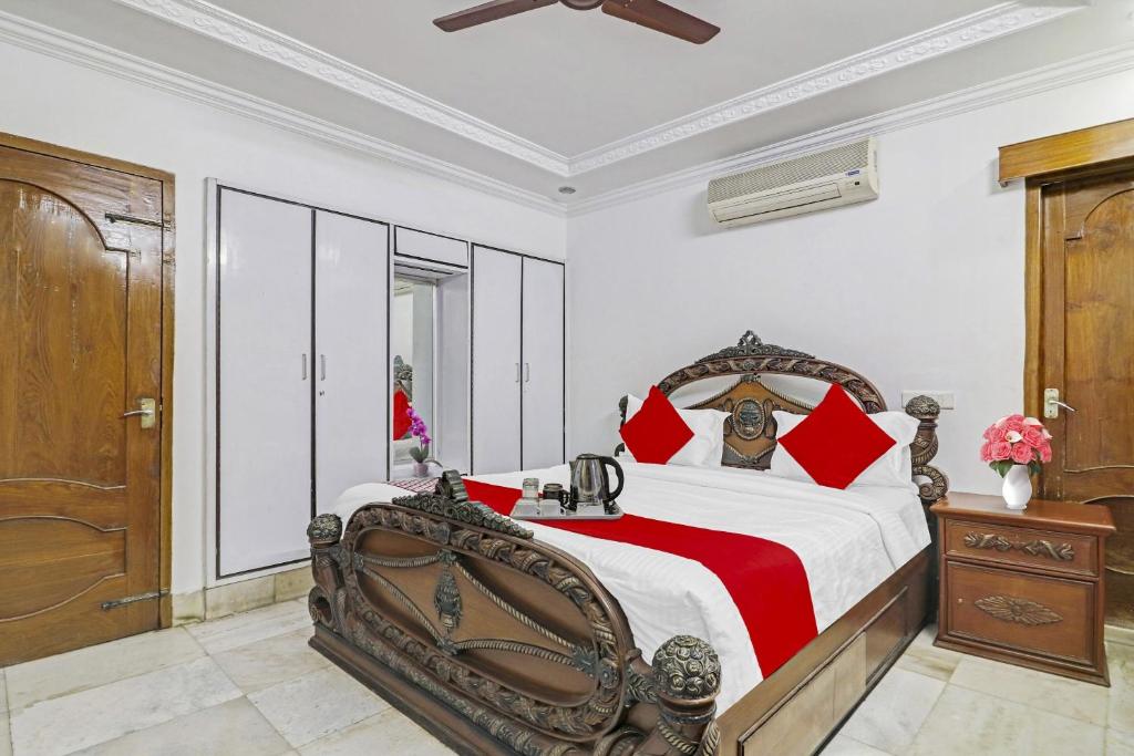 a bedroom with a large bed with red pillows at Super Hotel O Alpine Glow Crest in Hyderabad