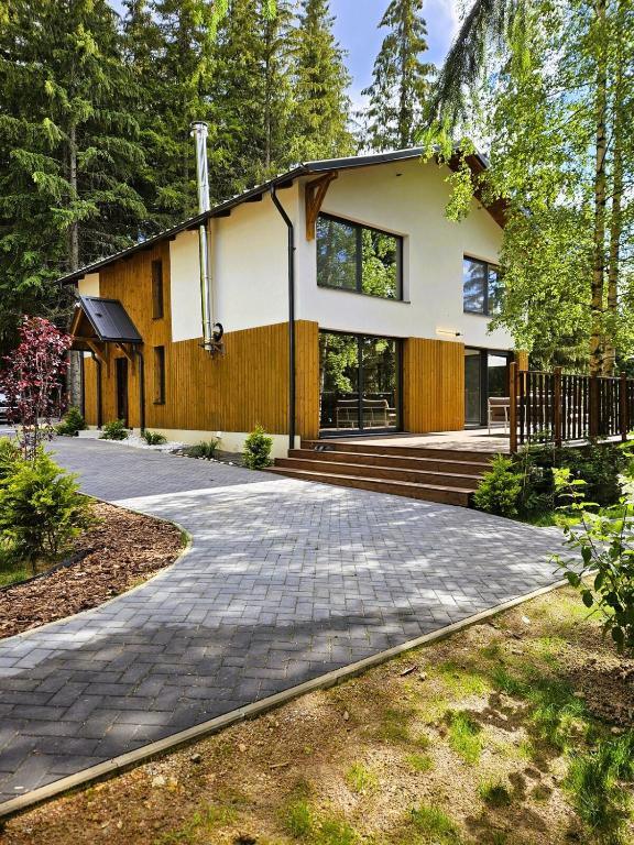 a house in the woods with a driveway at PineHills in Mărişel
