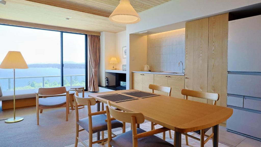 a kitchen and dining room with a table and chairs at ジローズガーデン in Ishinomaki