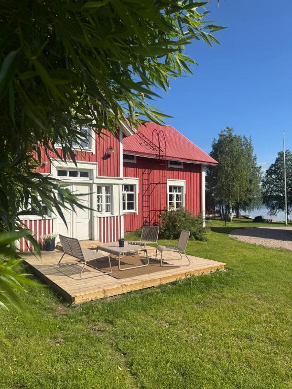 a picnic table and two chairs on a deck in front of a red building at Lapland Heritage Villa in Ranua