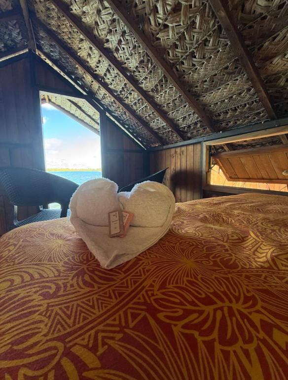 a heart shaped pillow sitting on top of a bed at Faimano Lodge & Car in HUH