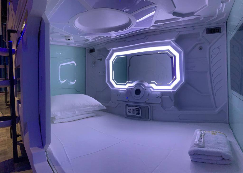 a small room with a bed and a tv at Jianpuke Space Capsule Backpacker Hostel in Sihanoukville