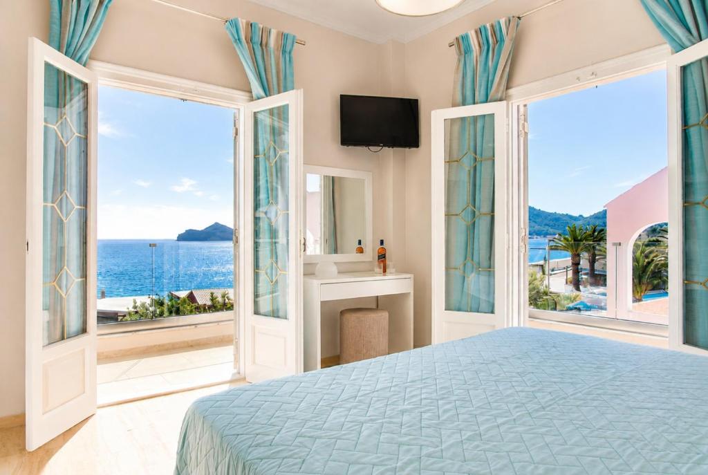 ein Schlafzimmer mit Bett und Meerblick in der Unterkunft Azure Mare Studios in Agios Georgios Pagon