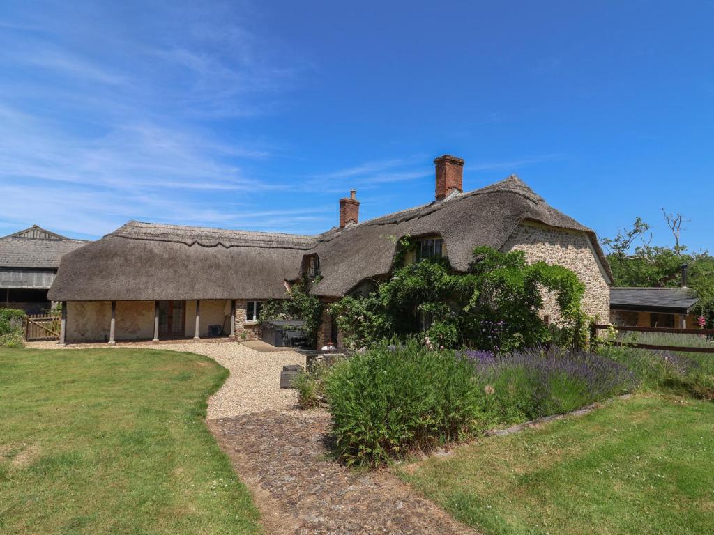 an old house with a thatched roof and a yard at Garden View in Wellington