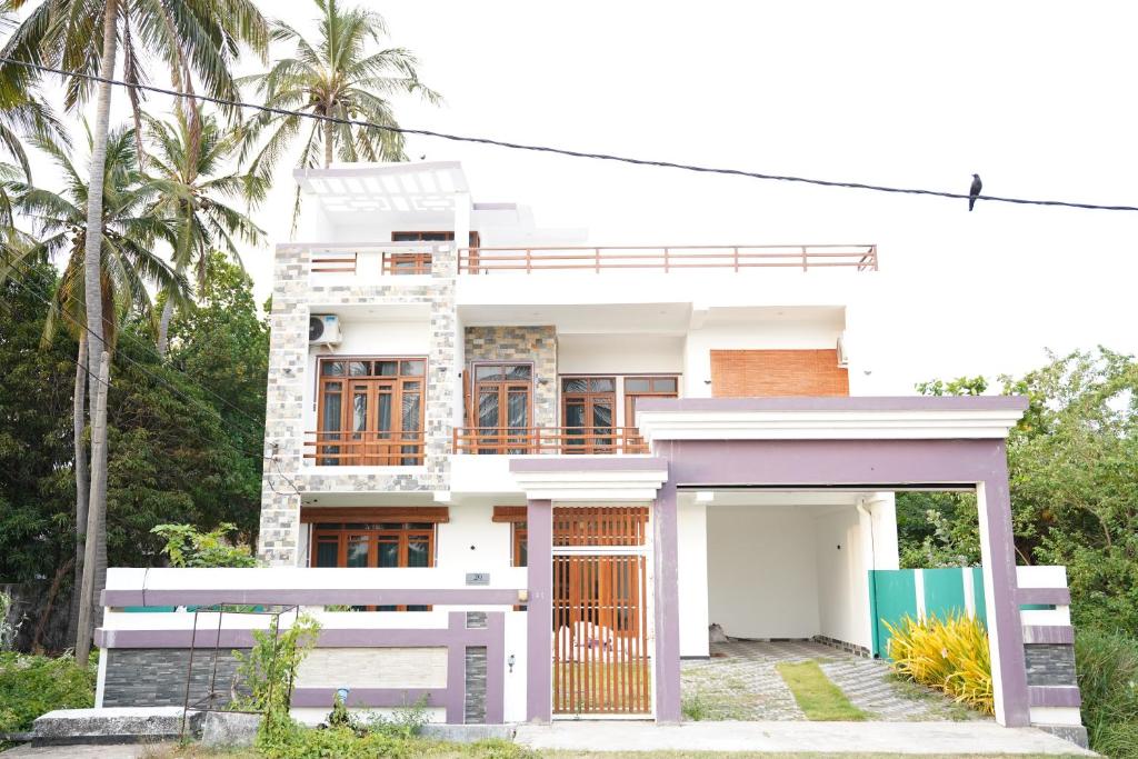 a white house with a gate in front of it at Harbour Front Villa in Trincomalee