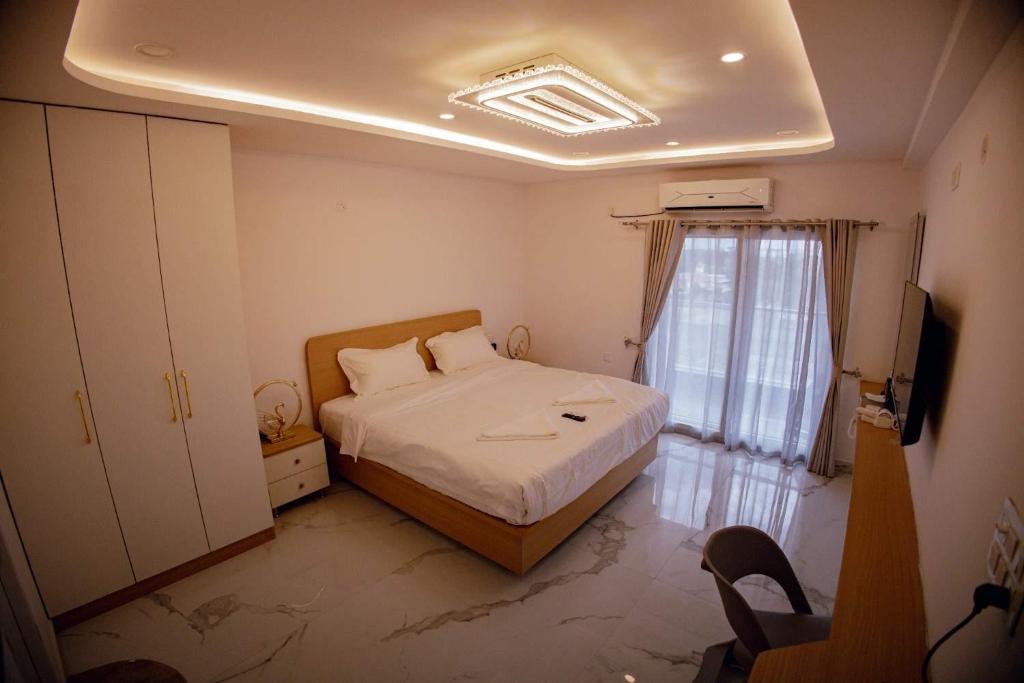 a small bedroom with a bed and a window at Hotel Vibrama in Tirupati