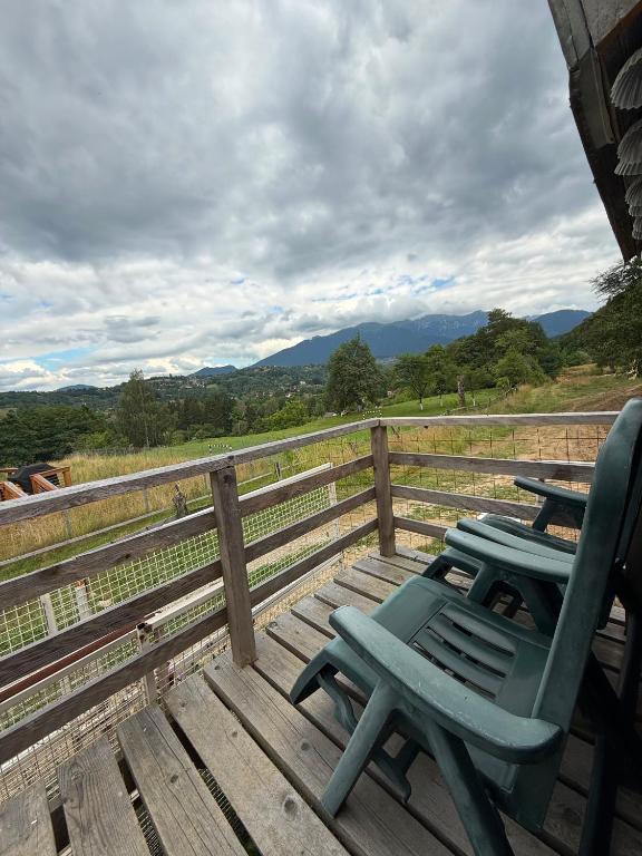 two green chairs sitting on a deck with a fence at Britania Hobbit in Predeluţ