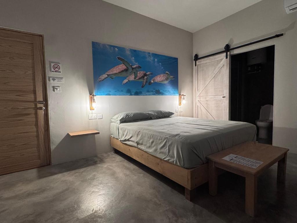 a bedroom with a bed and a painting on the wall at La Cabane D Eté in Port Mathurin