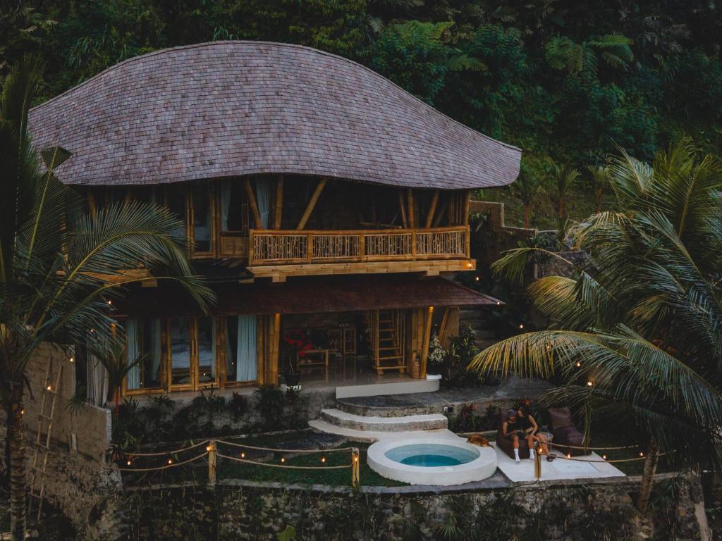 a house with a pool in front of it at Uma Bali-Bamboo House in Selat