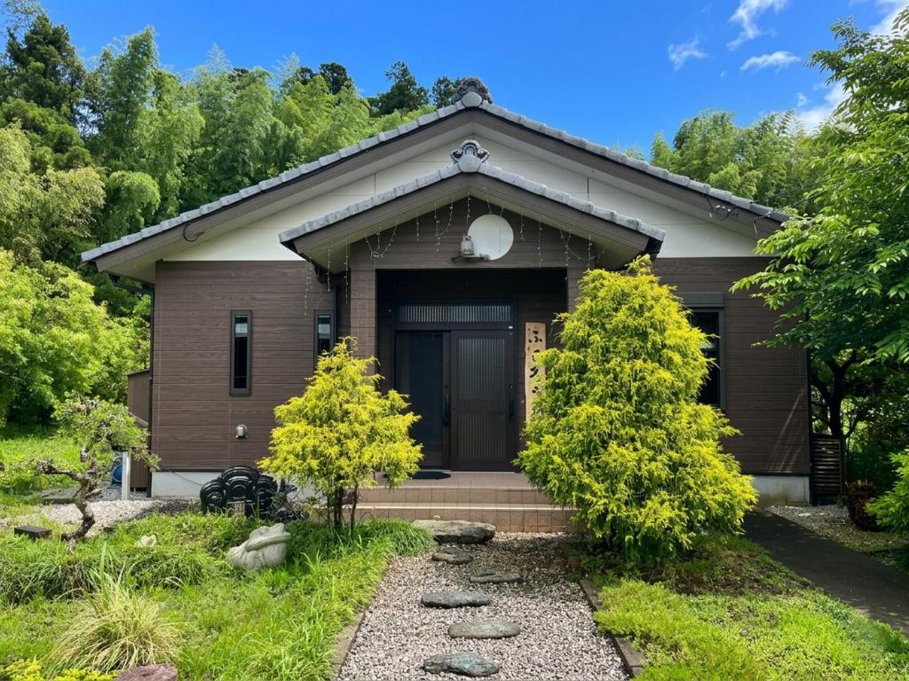 ein Haus mit einer Haustür und Bäumen in der Unterkunft Fukuroutei in Sosa