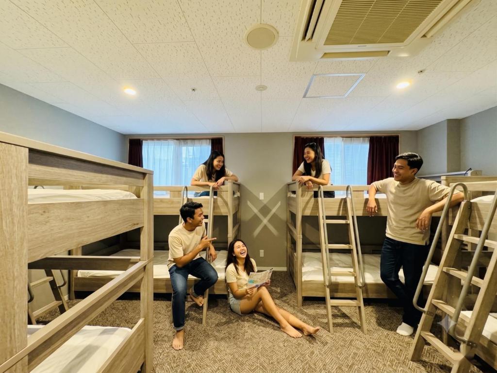 a group of people in a room with bunk beds at BANDE Hotel in Namba in Osaka