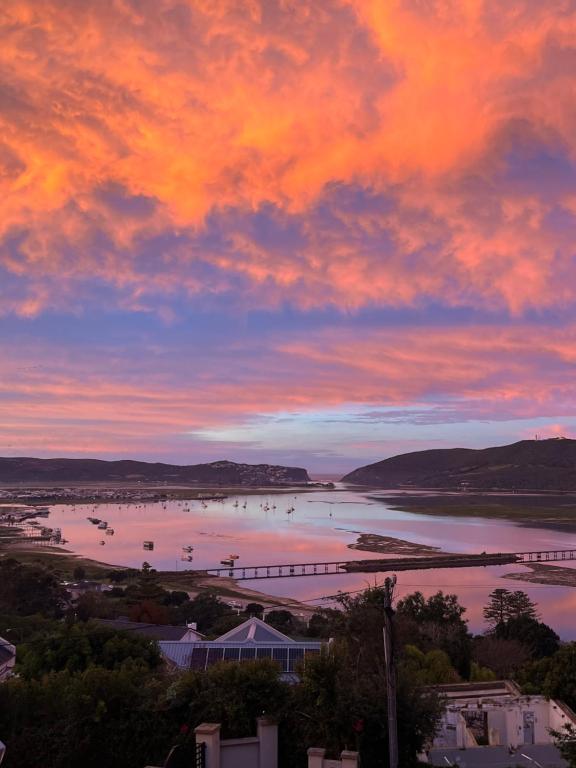 a sunset over a body of water with a bridge at De View in Knysna