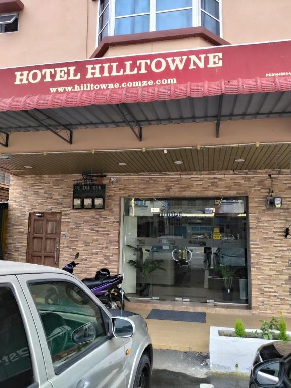 a hotel window with a car parked in front of it at Hotel O Hilltowne in Kampong Kawak