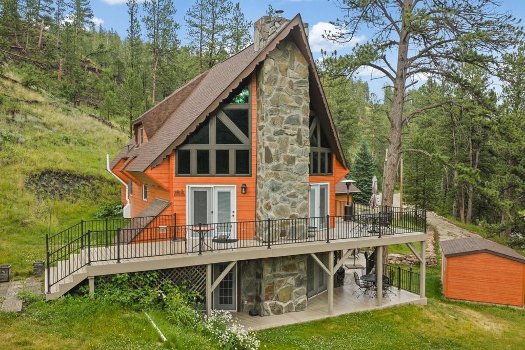a small house with a porch and a deck at Stones Throw in Hill City