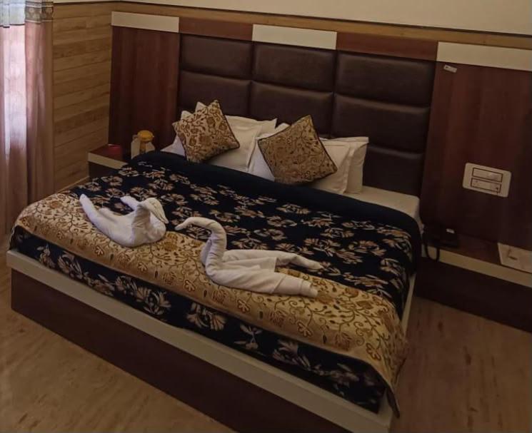 two swans laying on a bed in a bedroom at Mata Guest House in Katra