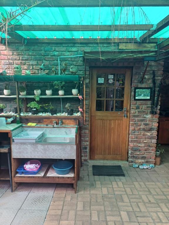 a house with a sink in front of a door at Whispering Gardens in Stilbaai