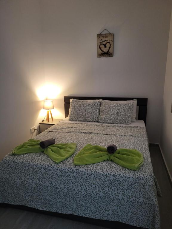 a bedroom with a bed with a green bow on it at Chryso Apts Protaras in Protaras