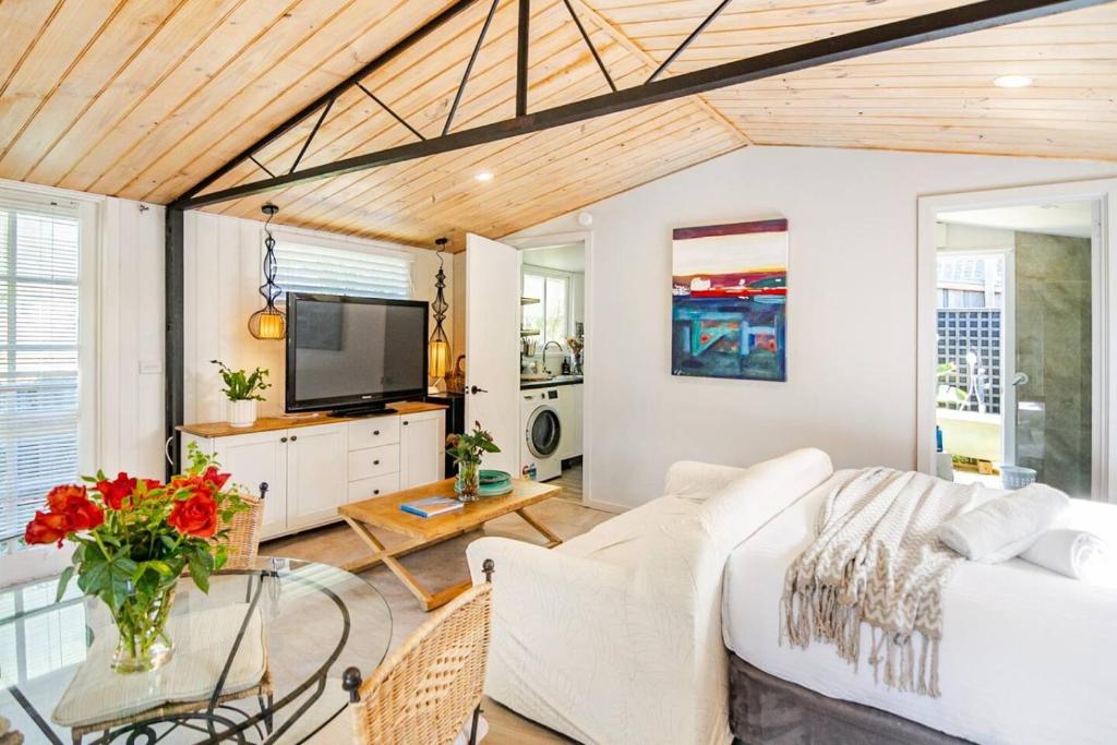 a living room with a white couch and a tv at Chiara's Wellness Studio Sauna and Outdoor Bath in Sorrento