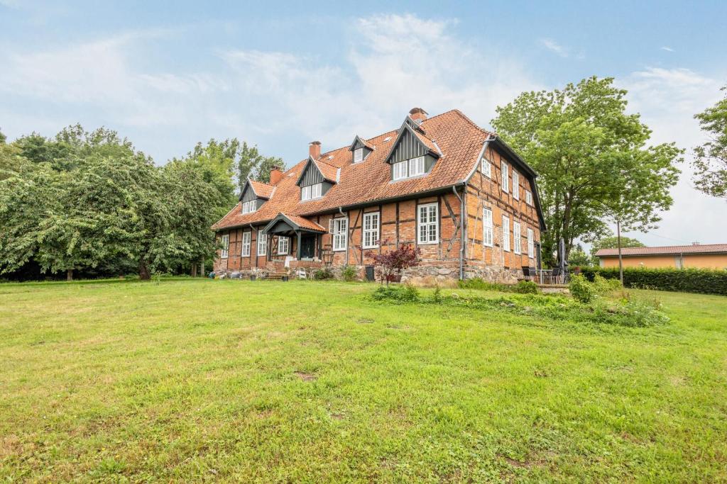 an old brick house with a large grass field at Gutshaus Benckendorf - Wohnung Erde in Dassow
