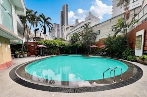 a large swimming pool in the middle of a building at Manhattan Hotel Bangkok in Bangkok