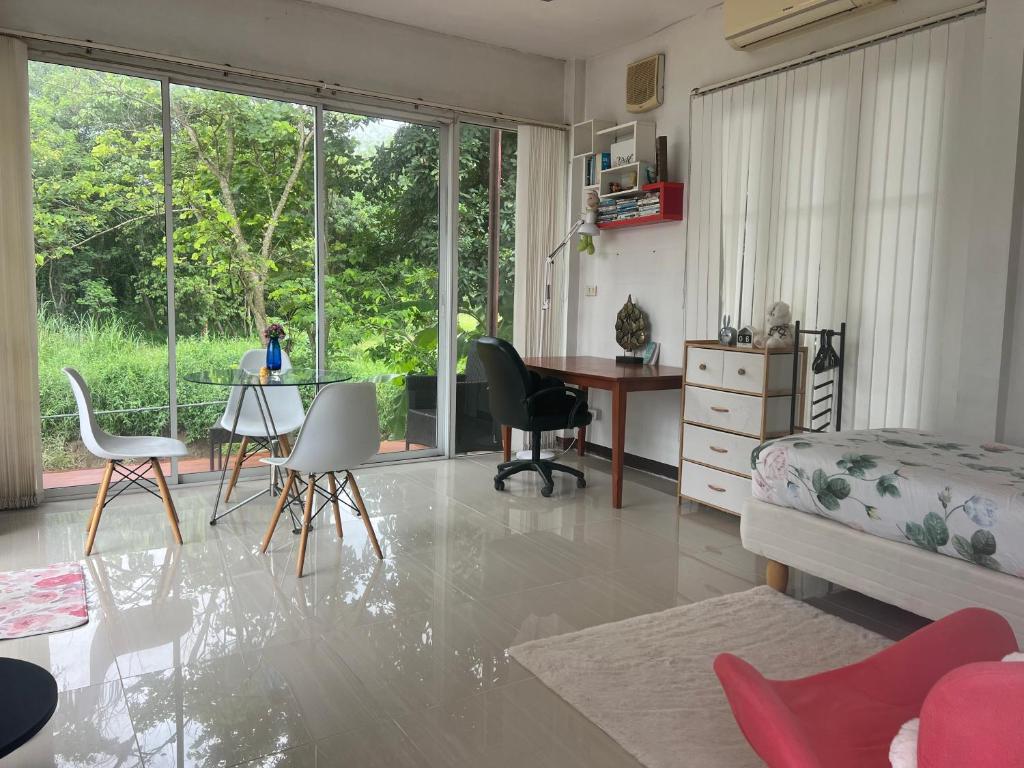 a living room with a desk and a table with chairs at Mae Wad House in Ban Oi