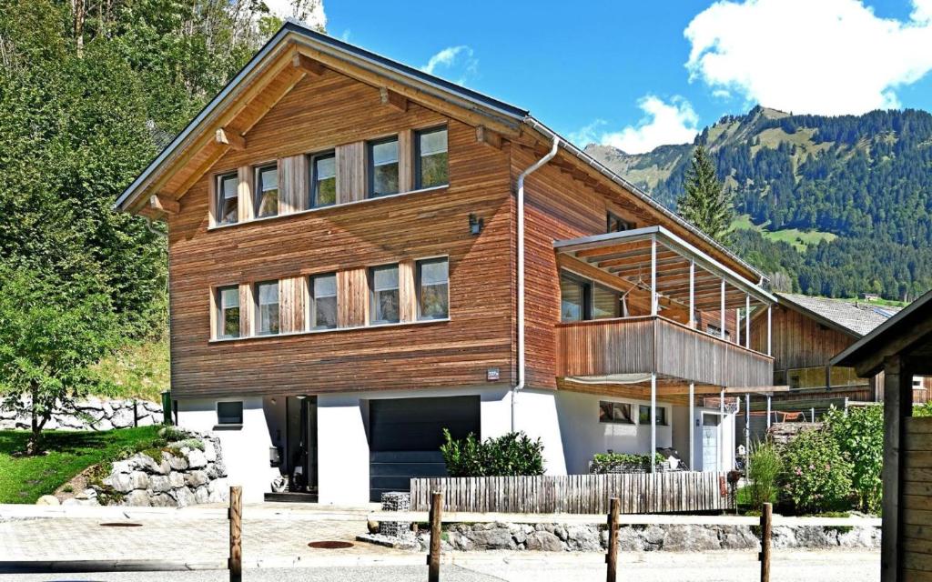 ein Holzhaus mit einem Zaun davor in der Unterkunft Hausblick in Au im Bregenzerwald