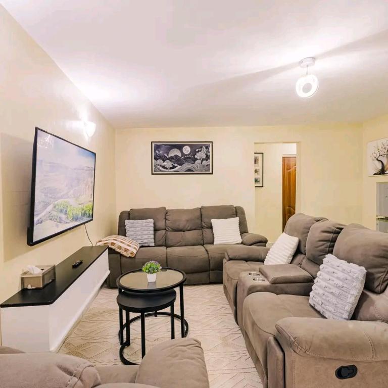 a living room with a couch and a table at Cozy stays in Giachumi