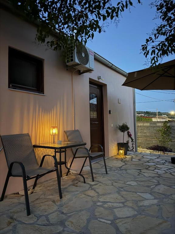 a patio with a table and chairs and a television at Salitzo Apartment Palairos in Paleros