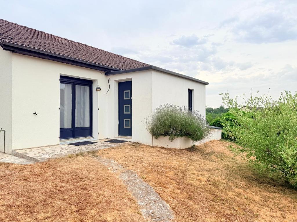 a white house with a blue door at Le Clos Tranquille in Saint-Privé