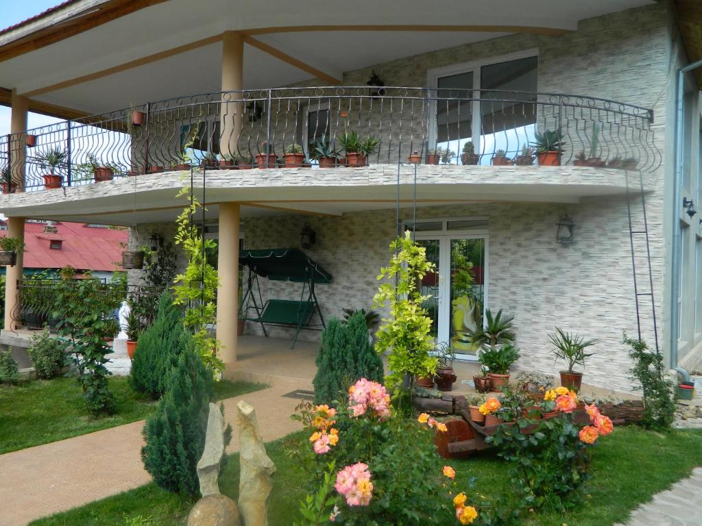 una casa con balcone con piante e fiori di Pensiunea Casa Cornelia Mahmudia a Mahmudia