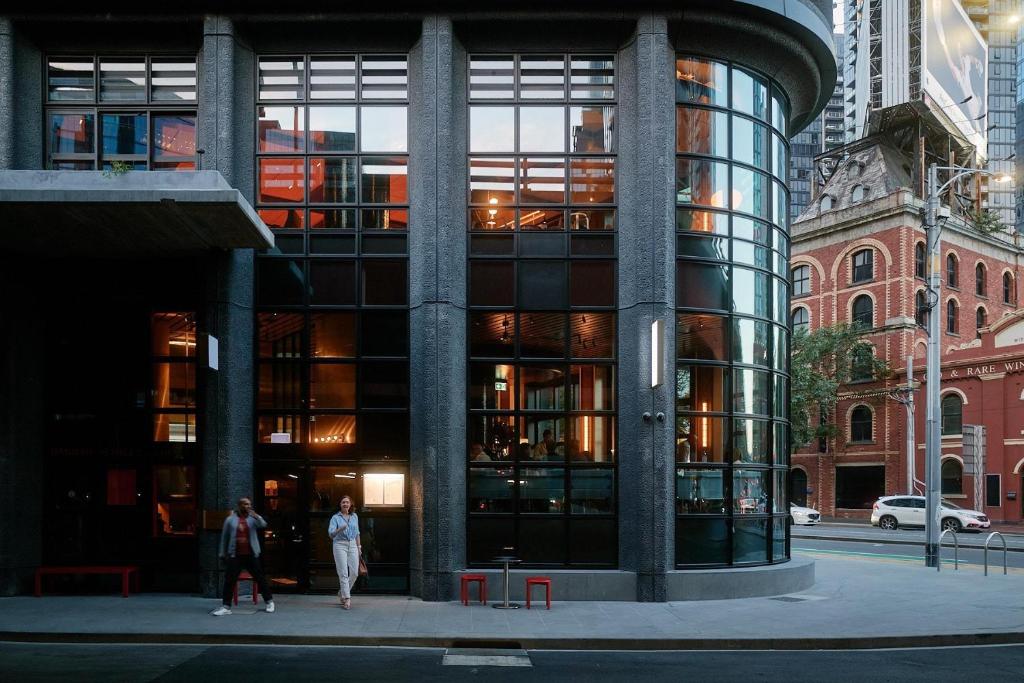 a building with people walking in front of it at Hannah St Hotel Melbourne in Melbourne
