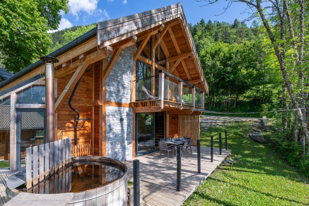 a house with a wrap around porch with a deck at Les chalets d'Éléna in Saint-Jean-Saint-Nicolas