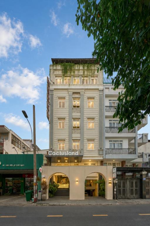 a tall white building with a sign on it at Cactusland Hotel Tan Binh Near T3 Station in Ho Chi Minh City