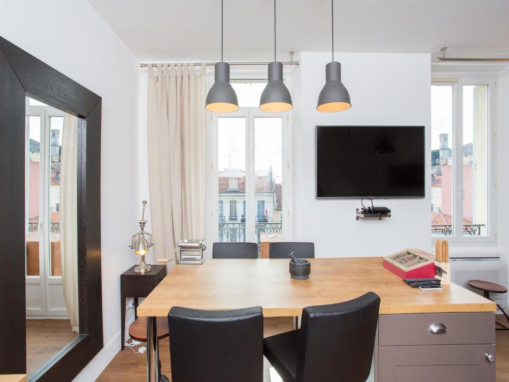 d'une salle à manger avec une table, des chaises et une télévision. dans l'établissement Budin Sea Cannes, à Cannes