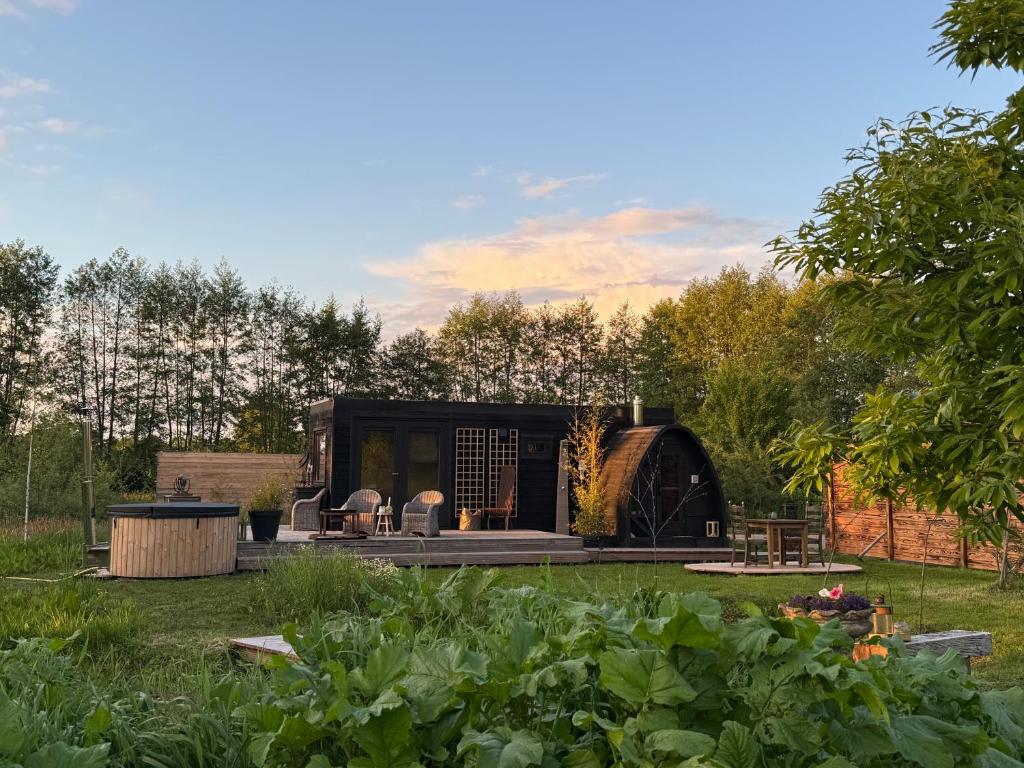 a garden with a black house in a field at Het Kleine Genoegen in Heelweg