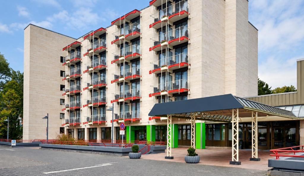 a large building with a parking lot in front of it at Sunday Hotel Bad Soden in Bad Soden am Taunus