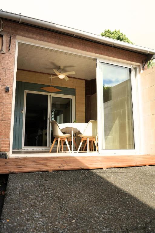 a screened in porch with a table and chairs at Bungalow Le Cocotier in Sainte-Rose