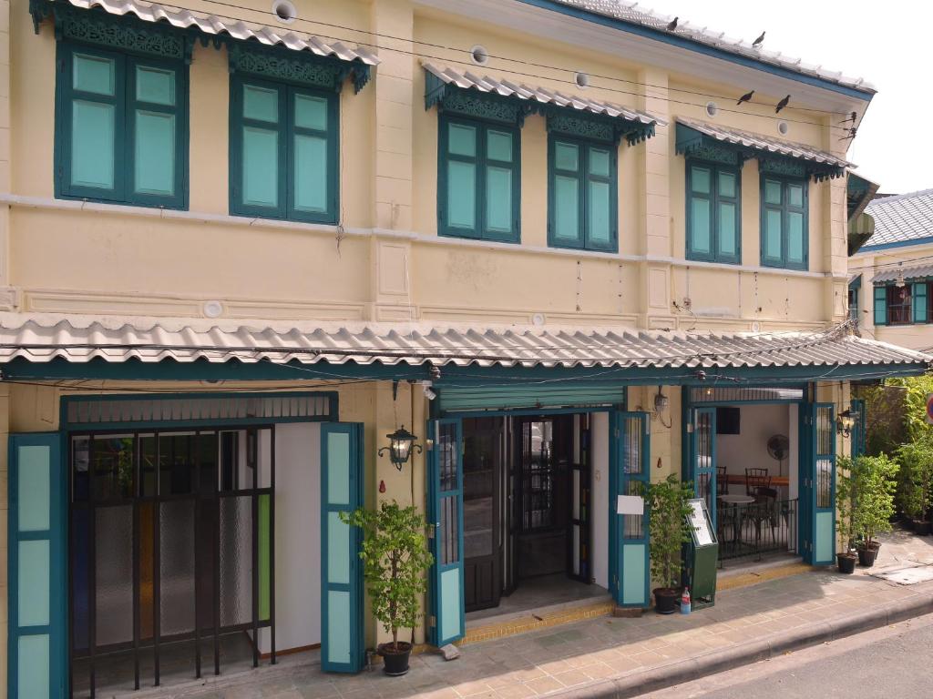 a building with blue doors and windows on a street at Neighbor Phuthon in Bangkok