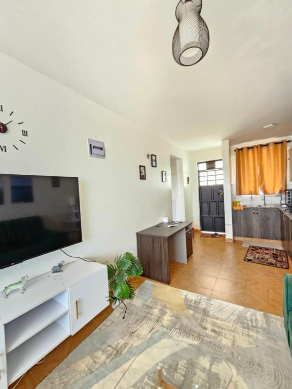 a living room with a large tv and a table at DSTAY HOMEs in Eldoret