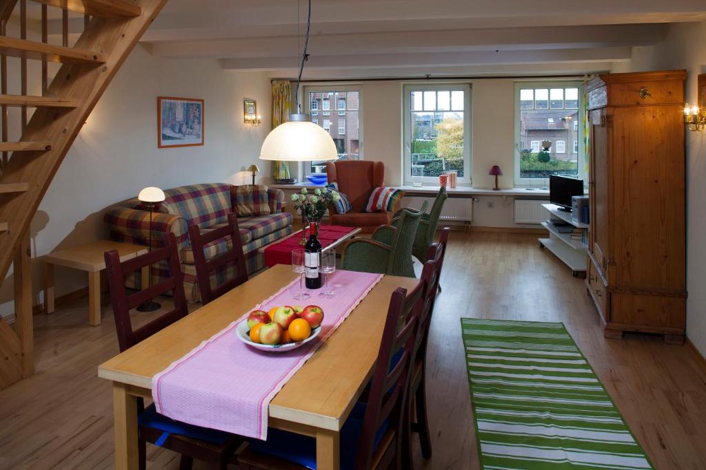 a living room with a table with a bowl of fruit on it at Hafenambiente in Husum