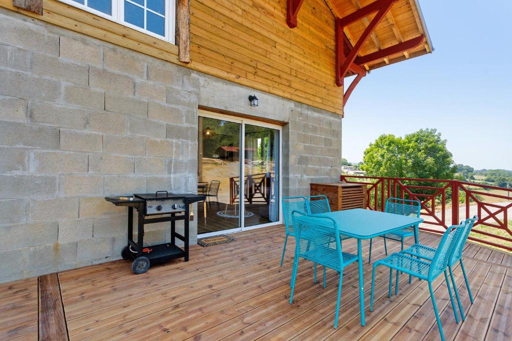 a patio with a table and chairs on a deck at Maison Mendi Borda Pays Basque in Larribar-Sorhapuru