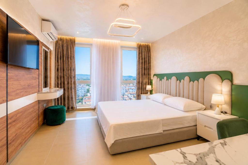 a bedroom with a large bed and a large window at Oryn Suites in Tirana