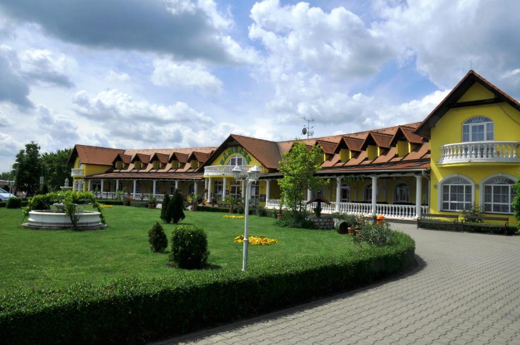 um grande edifício amarelo com um pátio verde em Hotel Zámeček em Mikulov