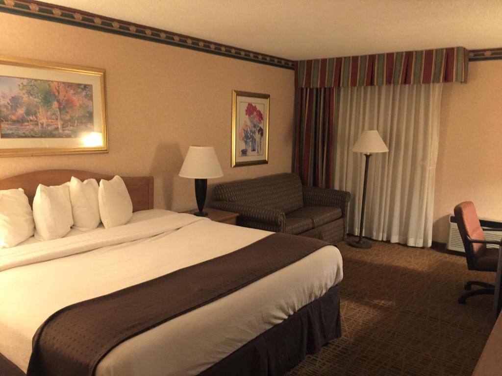 ein Hotelzimmer mit einem Bett und einem Stuhl in der Unterkunft Americas Best Value Inn & Suites-Boise in Boise