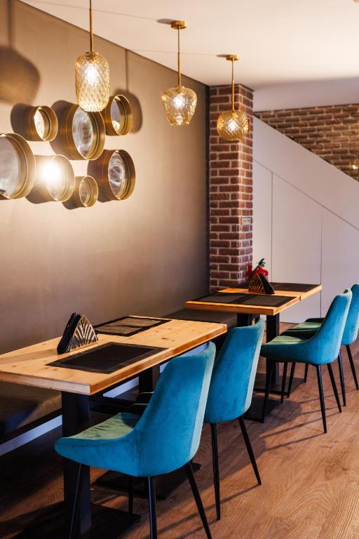 a dining room with wooden tables and blue chairs at &Tales Suites - Óbidos in Óbidos