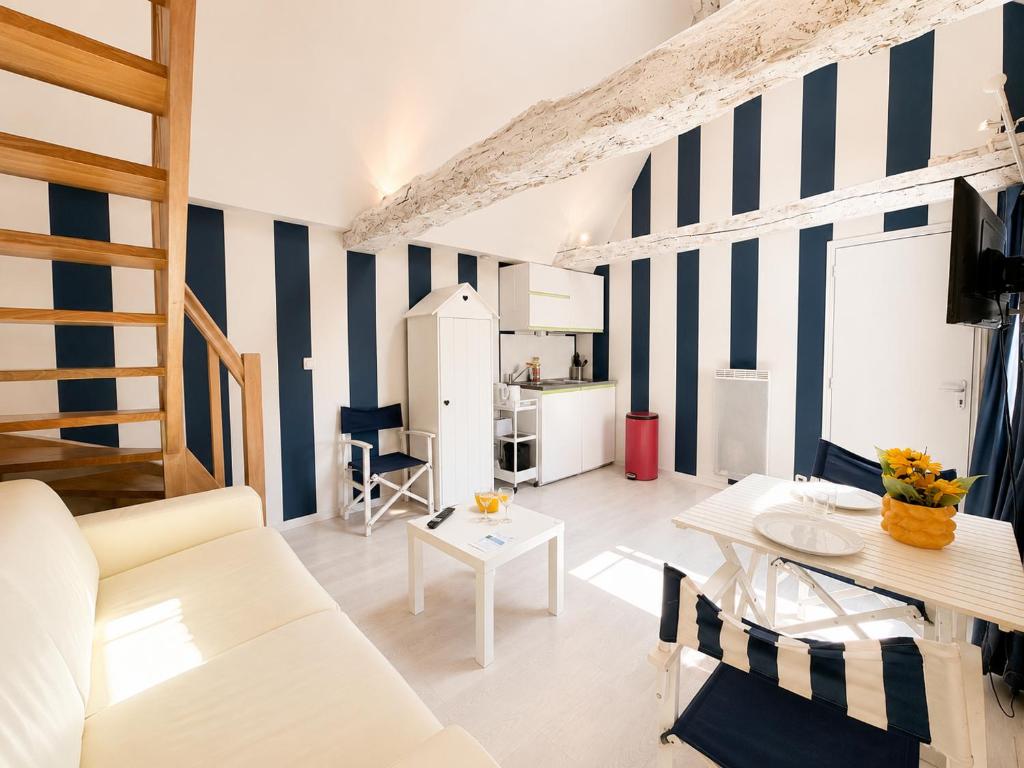 a living room with blue and white striped walls at Apt duplex ou plain pied tout confort plein centre ville Bayeux proche commerces, restaurants, avec terrasse privative ou jardin commun aménagé clos, parking gratuit à proximité, proche plages du débarquement in Bayeux